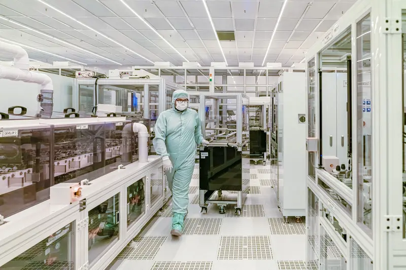 Technician in a gown walking through a pharmaceutical cleanroom